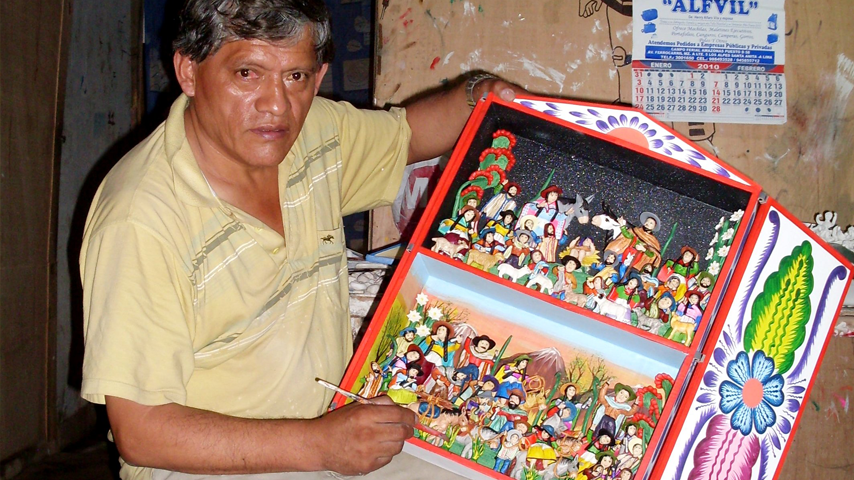 César Urbano sosteniendo un&amp;nbsp;retablo ayacuchano en proceso